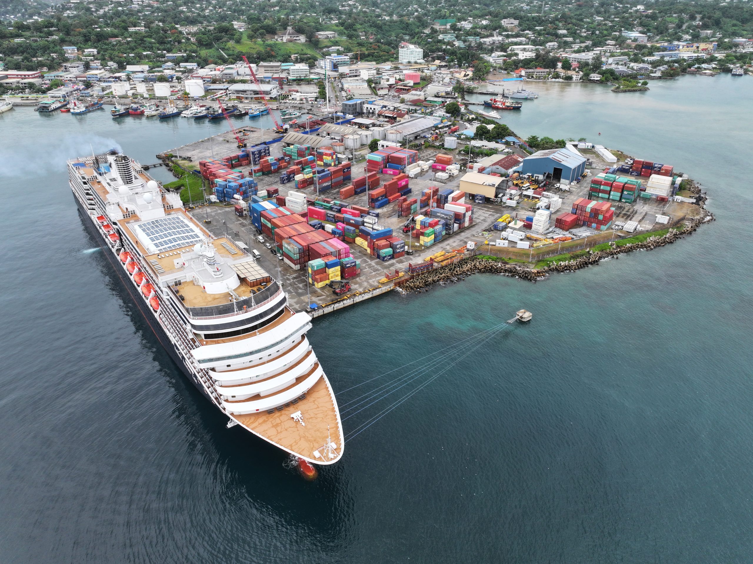 Aerial view of Honiara port, shipping containers, vessels, and coastline.
